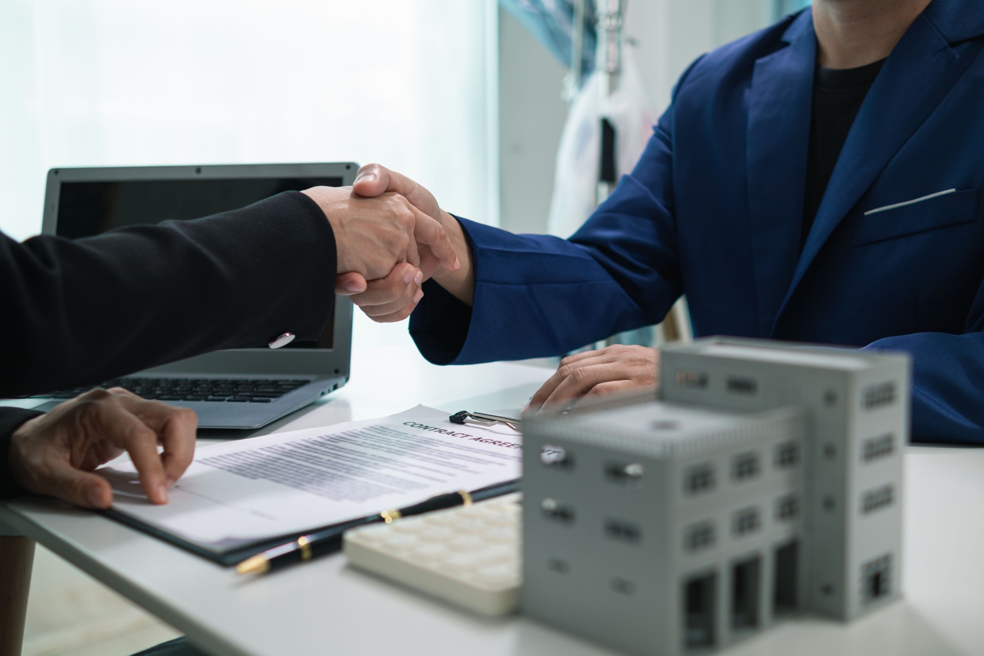 real estate agent shakes hands with customer after agreeing to sign sales contract and signing contract deliver real estate customer. concept of success in agreeing to sign real estate sales contract